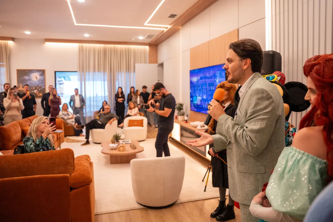 André Herdy fala aos convidados na sala da casa